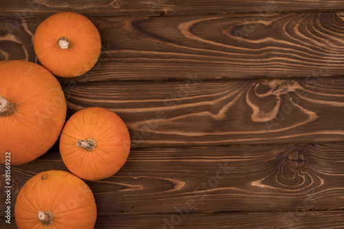 Autumn small orange pumpkin on a wooden table, the harvest, the symbol of Halloween