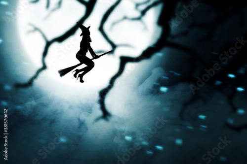 Silhouette of witch woman with a hat flying on a magic broomstick
