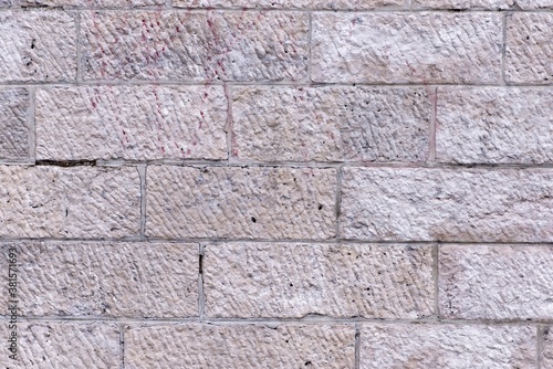 A grey bricked rectangular wall along with scratch pattern