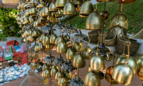 Closeup view of many beautiful old fashioned golden Christmas bells hanging as new year toys, horizontal picture