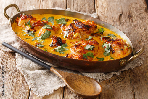 Kuku Paka is a spiced chicken and coconut curry dish that is full of exotic flavours closeup in the pan on the table. Horizontal