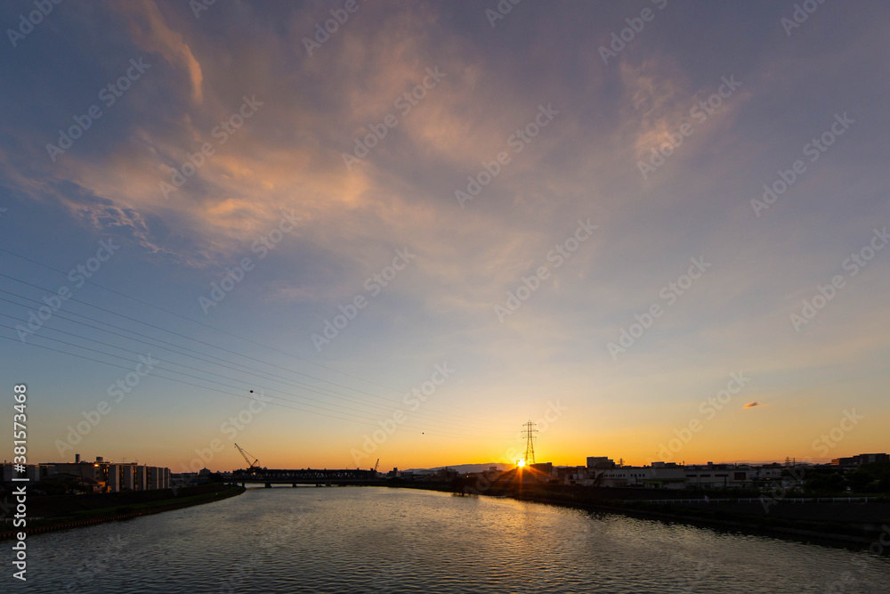 幅広い河川に夕日が沈む光景