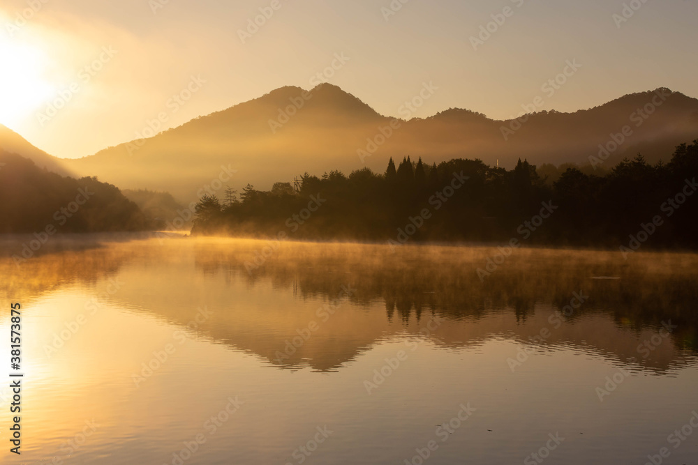 朝焼けの光景が映り込む静かな湖面
