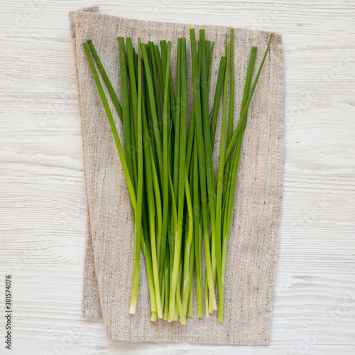 Raw Green Onions on a white wooden table, top view. Flat lay, overhead, from above.
