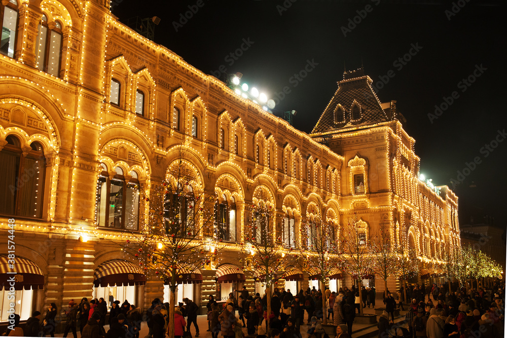 Celebration lights and decorations on Red Square for festive Christmas and New Year. Shining yellow lights on facade GUM in Moscow, Russia. Night cityscape of Moscow