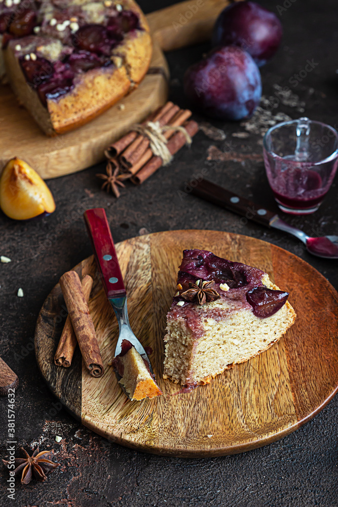 Homemade sweet plum pie or cake with nuts and spices on wooden board, dark brown stone background. Fruit pie. Rustic style. Selective focus. Homemade sweet plum pie or cake with nuts and spices on wooden board, dark brown stone background. Fruit pie. Rustic style. Selective focus.