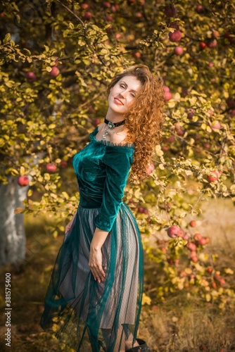 Woman in green velvet romantic dress, ladies pretty style, autumn nature at background