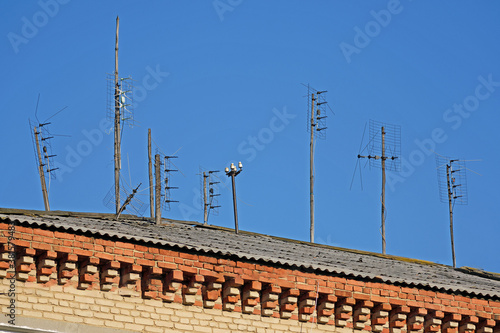 Analog TV antennas are mounted on the roof of the building