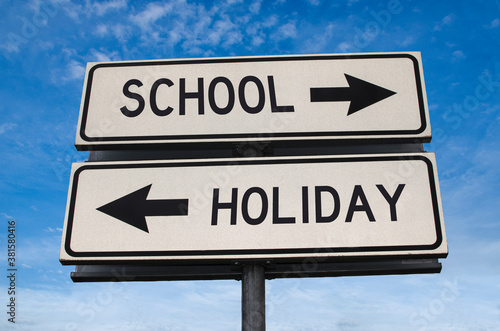 School vs holiday. White two street signs with arrow on metal pole with word. Directional road. Crossroads Road Sign, Two Arrow. Blue sky background. Two way road sign with text.