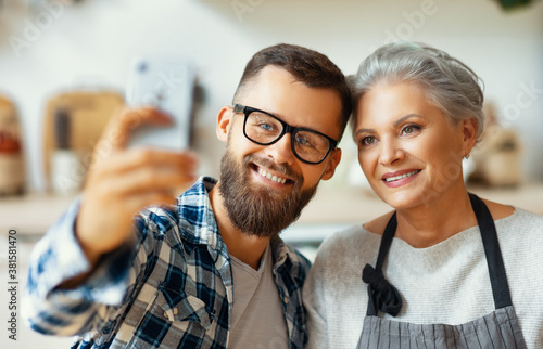 Happy mother and son taking selfie while cooking at home.