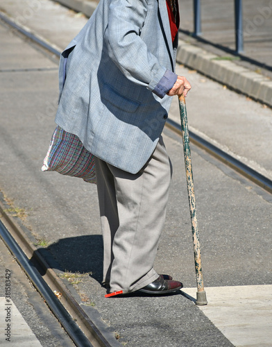 Old man walks with a stick on the city street