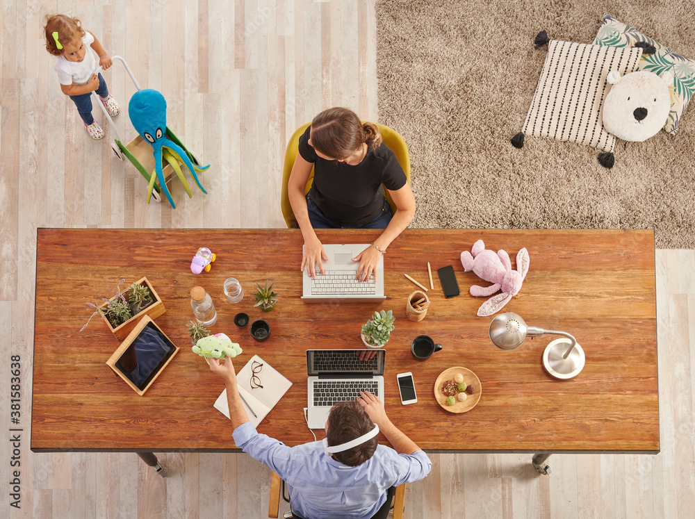 © UnitedPhotoStudio - Working from home family style with baby, wooden table, laptop lamp and toy decor.
