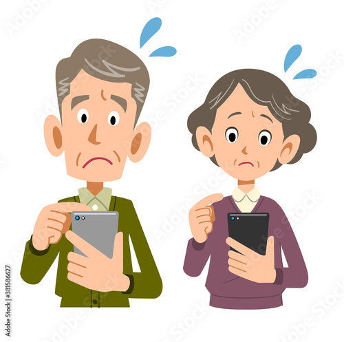 困った顔でスマートフォンを操作するシニア夫婦
