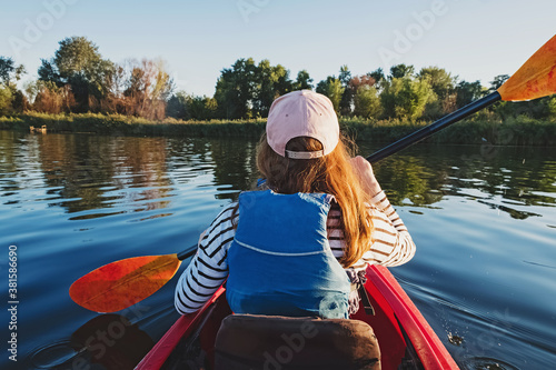 Woman paddling the kayak on river or lake