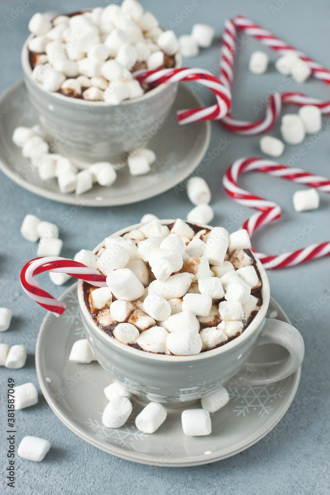 Mugs filled with hot chocolate and marshmallows and candy cane Mugs filled with hot chocolate and marshmallows and candy cane