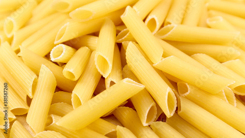 Penne Rigate Raw Pasta is a short pasta with oblique cuts and a ribbed surface. Traditional Italian pasta. Pasta background. Italian food ingredient top view.