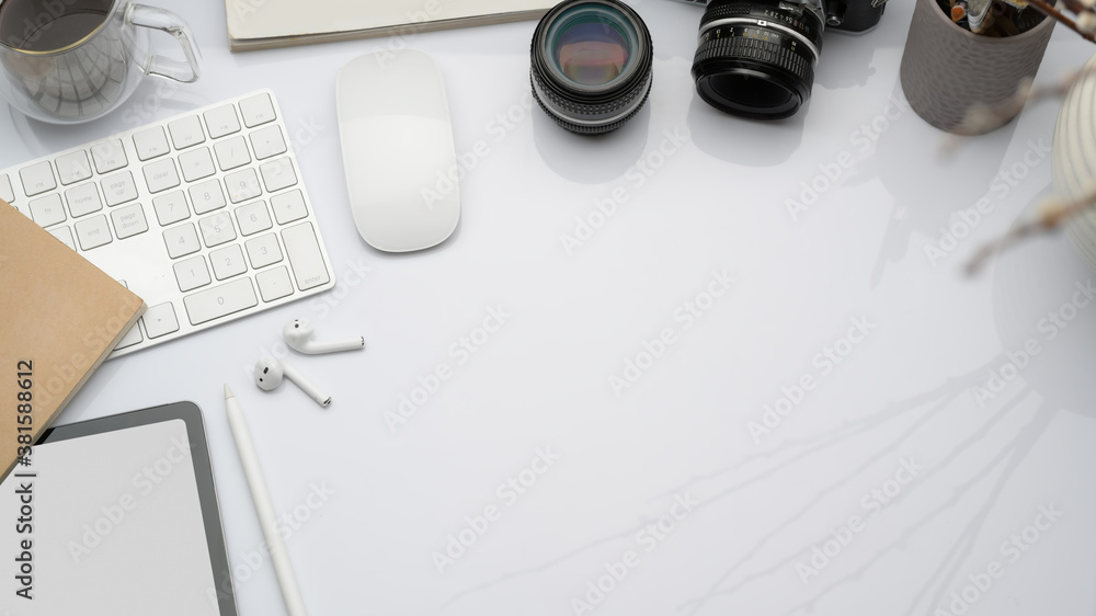 Workspace with digital devices, camera, office supplies and copy space in white concept office Workspace with digital devices, camera, office supplies and copy space in white concept office
