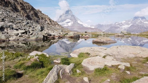 Alpine meadows around Riffelsee Lake with mirror of Mount Matterhorn and Swiss Alps. Zermatt, Canton of Valais, Switzerland. Riffelsee is located on Riffelseeweg trail on Gornergrat Bahn cog railway. photo