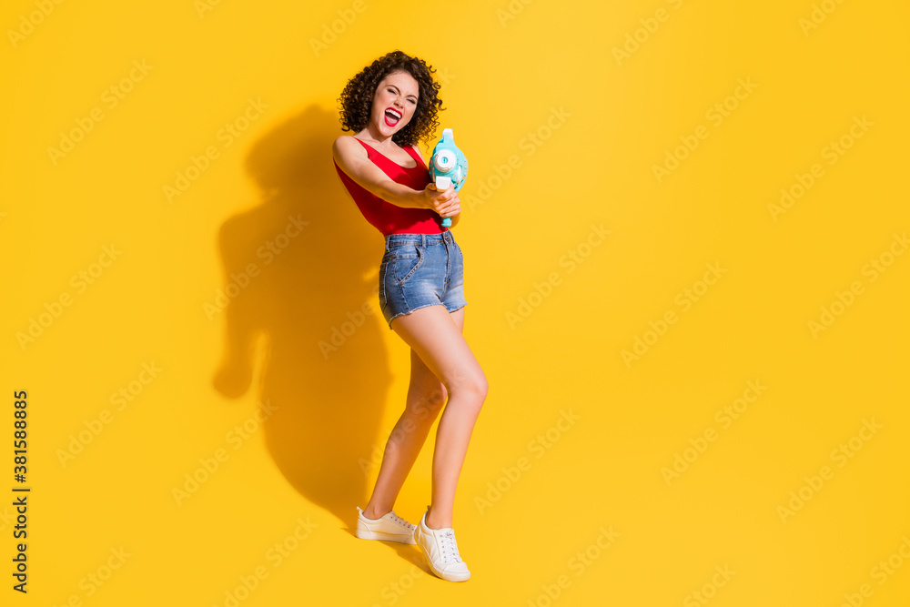 Full size photo of attractive shiny cute funky crazy wavy lady pool game champion water gun wear red singlet blue denim shorts white sneakers isolated yellow color background Full size photo of attractive shiny cute funky crazy wavy lady pool game champion water gun wear red singlet blue denim shorts white sneakers isolated yellow color background