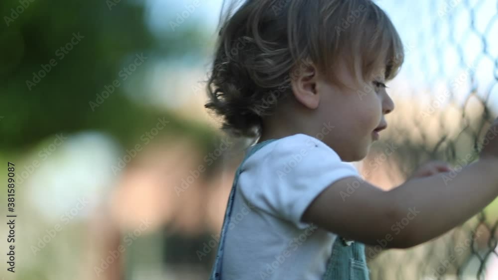 Baby portrait outside holding in to fence Baby portrait outside holding in to fence