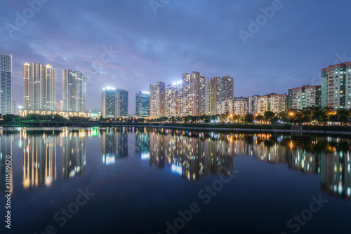 Buildings with reflections on lake at twilight at Thanh Xuan park. Hanoi cityscape at twilight period