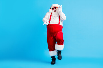 Full size photo of funky fat crazy santa claus with big abdomen beard dance x-mas christmas holly party club wear suspenders overalls sunglass boots isolated blue color background