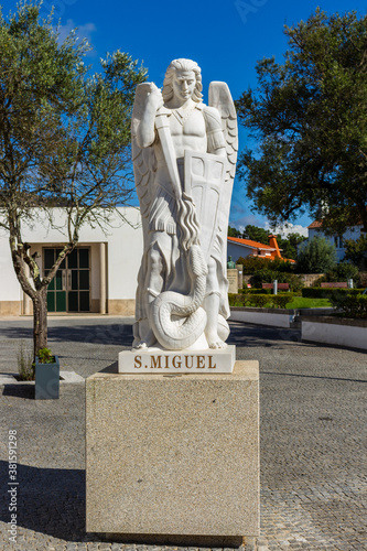 Marinhas / Esposende / Portugal - September 21, 2020: The archangel Michael statue with his sword and a huge phallic snake ie Satan, outside the he Mother Church of Sao Miguel Arcanjo. photo