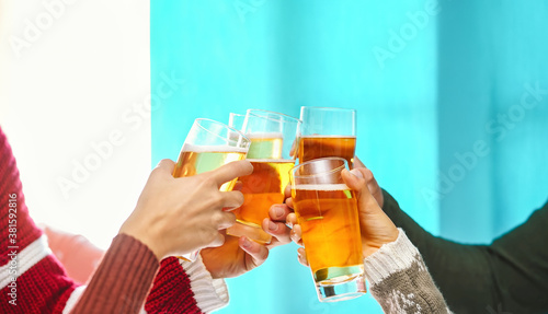 Happy friends doing celebratory toast in winter Christmas holidays - Young people drinking beer in xmas time - Youth culture lifestyle and traditional event celebration concept