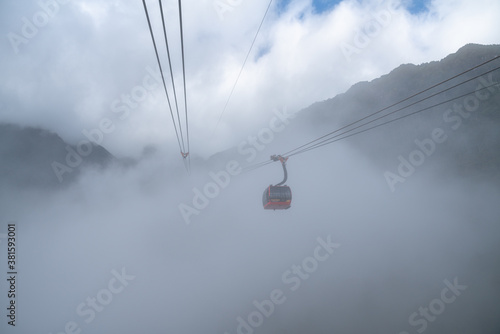 Lao Cai, Vietnam - Jan 3, 2019: The cable car to Fansipan mountain top with low clouds and mountain view in Sapa town