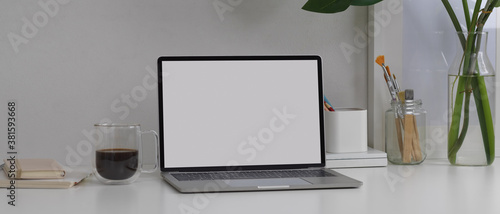 Mock up laptop on white table with stationery and decorations in home office room
