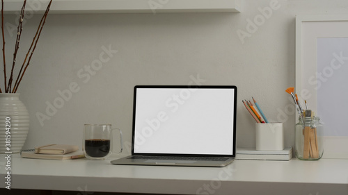 Mock up laptop computer in comfortable room with office supplies