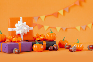 Halloween colorful gift boxes with pumpkins on orange background. Birthday, Halloween party celebration concept.