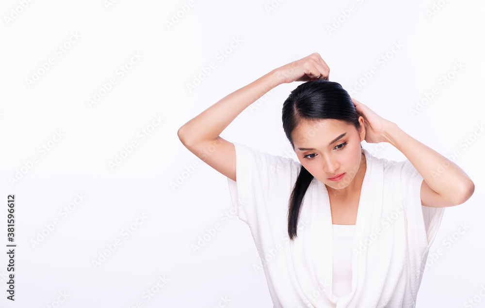 Glamour young woman using hair clip while sitting over isolated white background with copy space. Hair care concept. Glamour young woman using hair clip while sitting over isolated white background with copy space. Hair care concept.