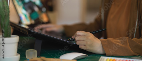 Female graphic designer working with digital tablet on computer desk