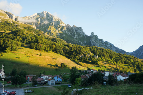 Pueblo de Sotres y montañas iluminadas por el sol al atardecer en Asturias
