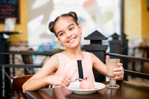 Girl eating cake in cafe smiling with beautiful white teeth