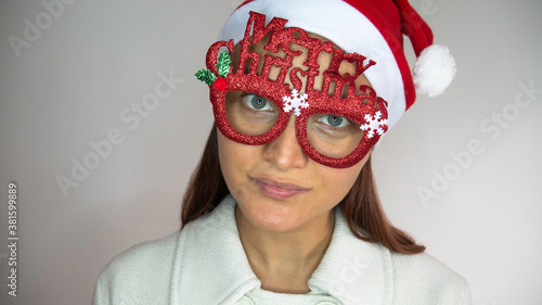 Caucasian Woman with Santa Claus Hat and Glasses Merry Christmas. Copy space for text.