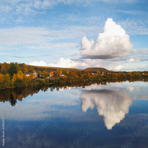 The scenery of Karasjok village and Karasjohka river with big cloud reflected in it, Norway  © Ilona