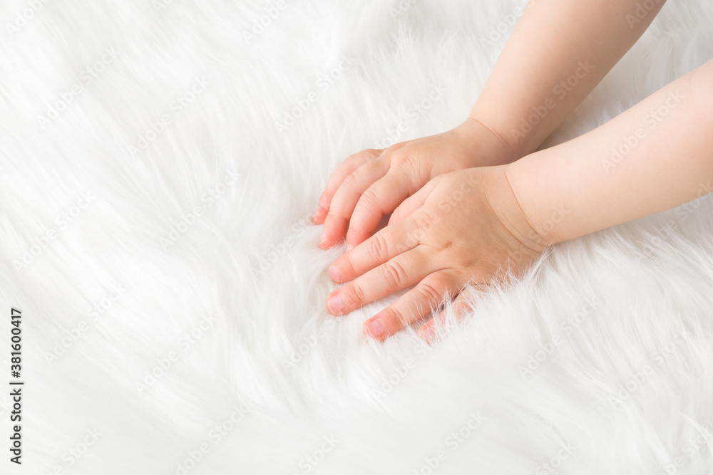 Baby girl hands touching white, soft, fluffy fur blanket. Closeup. Baby girl hands touching white, soft, fluffy fur blanket. Closeup.