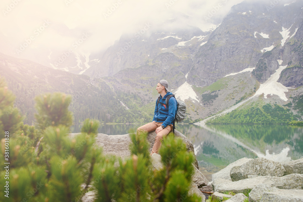 man relaxing on the lake and mountains sunny landscape