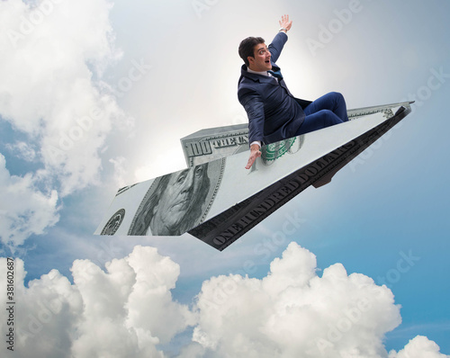 Businessman flying on paper plane in business concept photo