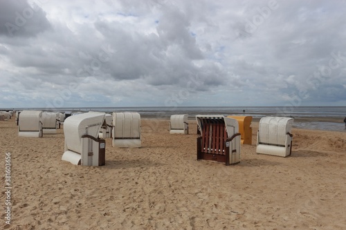 Beach chairs on a sandy beach by the North Sea. View of the wadden sea. Cuxhaven  North Germany  Europe.