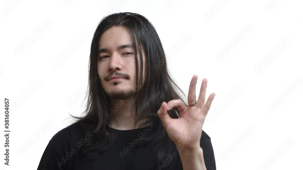 Close-up of handsome confident east-asian man with long dark hair, piercing and moustache, wearing black t-shirt, showing okay gesture, approve something good, guarantee quality Close-up of handsome confident east-asian man with long dark hair, piercing and moustache, wearing black t-shirt, showing okay gesture, approve something good, guarantee quality