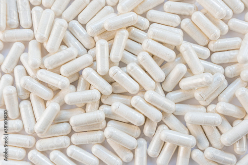 Light capsules close-up. The concept of vitamins, dietary supplements. Capsules in a white bottle, blue background. Copy space, minimalism, top view. Magnesium citrate.