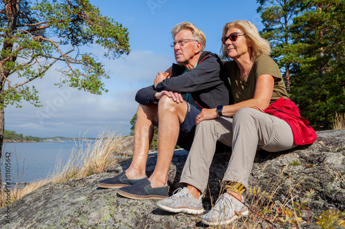 Senior hiking couple looking out on the see thinking of the future in the Swedish archipelago