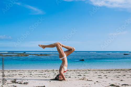 Young woman practicing yoga on coastline