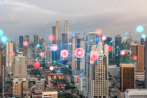 Photography Hologram of abstract technology glowing icons, panoramic cityscape of Kuala Lumpur at sunset, Malaysia, Asia