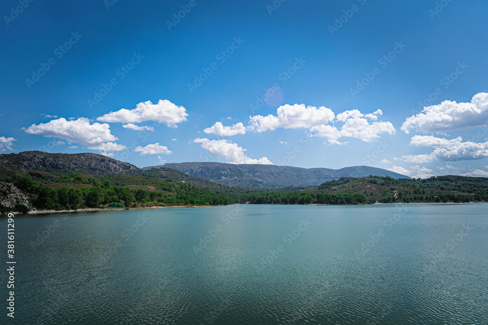 Vista del lago con las montañas y cielo nublado de fondo