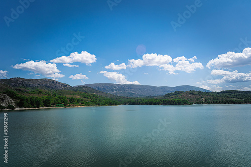 Vista del lago con las montañas y cielo nublado de fondo
