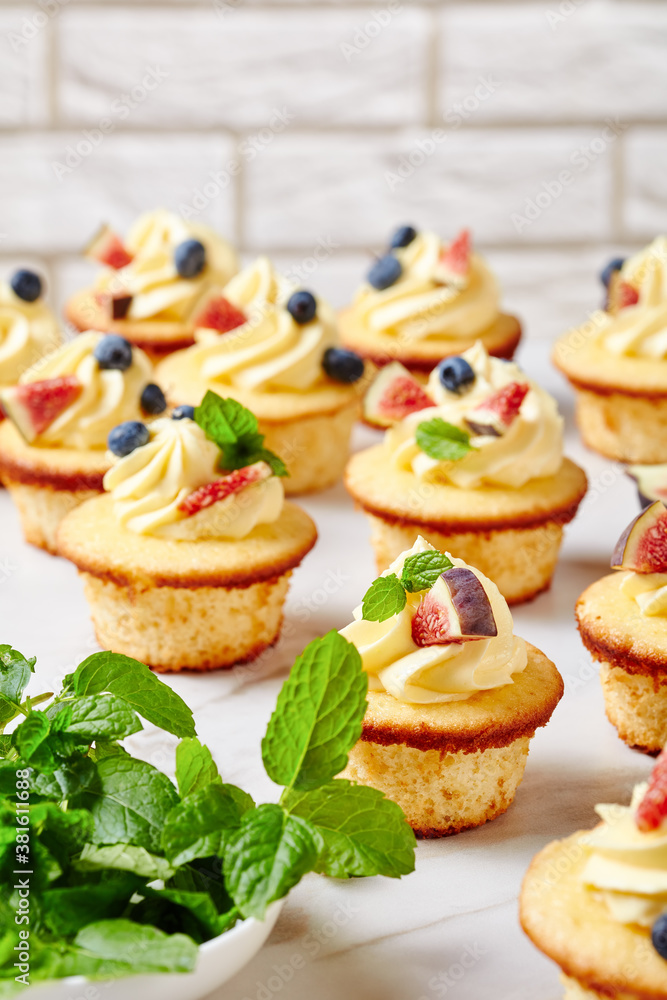 cupcakes with buttercream and berries on a table cupcakes with buttercream and berries on a table